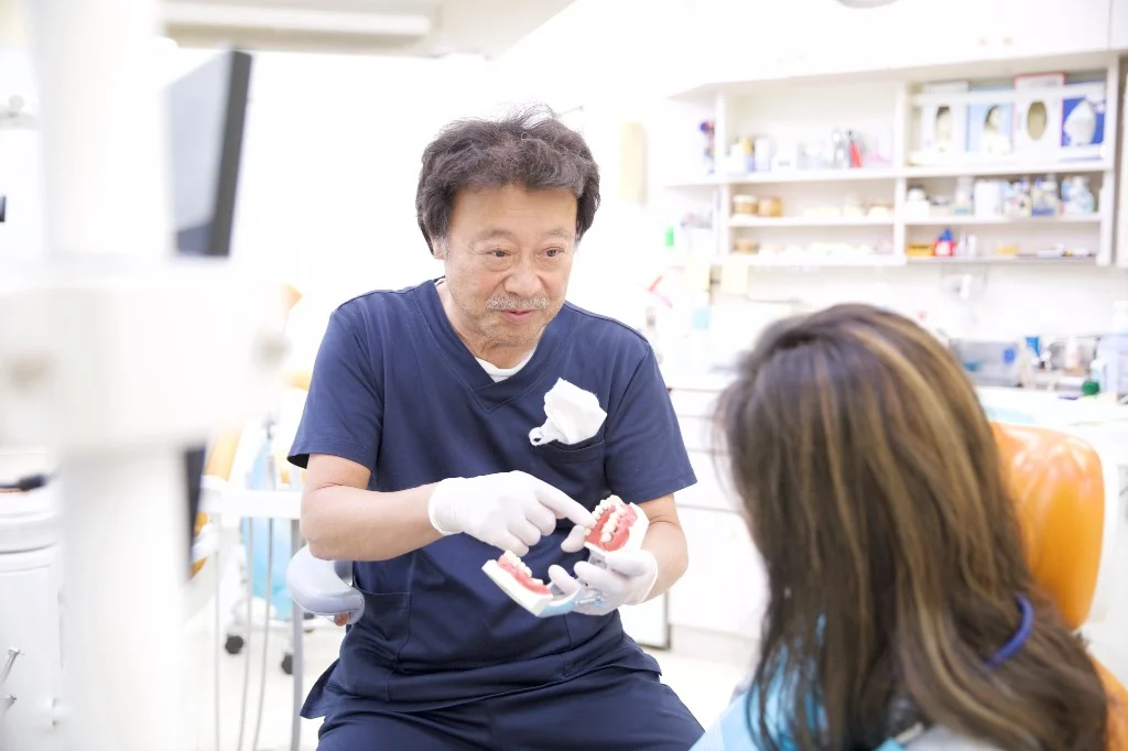 歯科模型を用いて顎の状態を説明する歯科医師