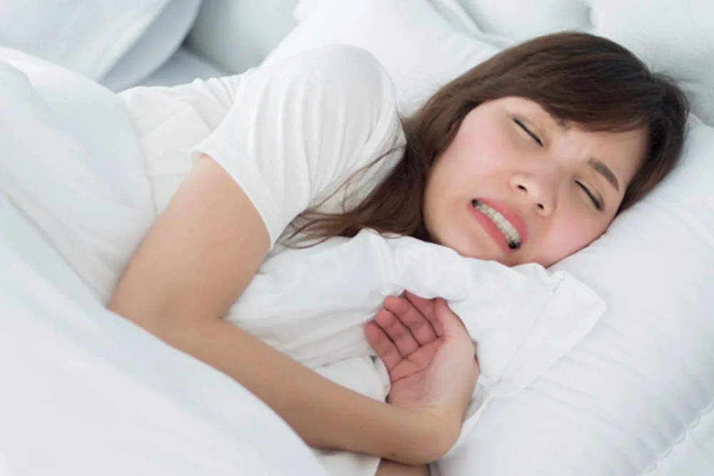 就寝中に歯を食いしばる女性