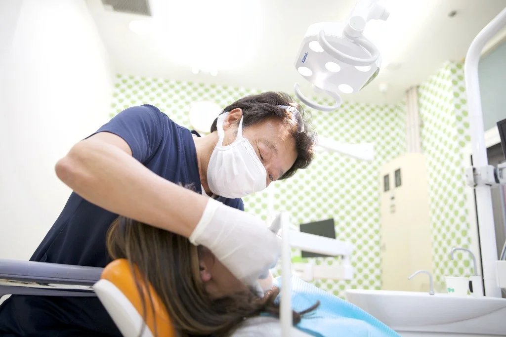 診療室で口腔内を診る歯科医師と患者